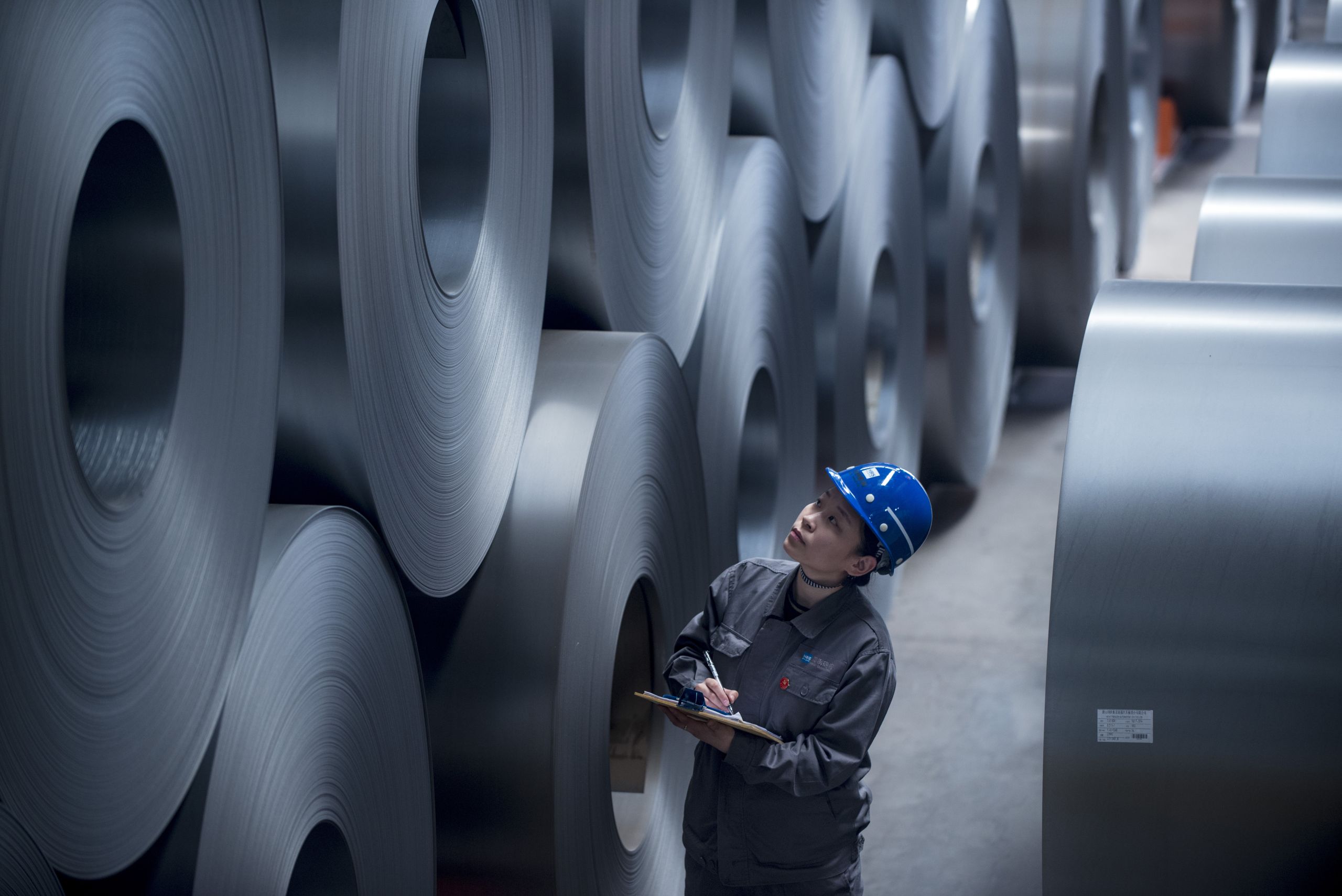 A worker checks rolled steel sheet at HBIS Tangsteel